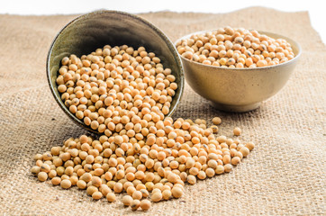 soybeans in ceramic bowl on sackcloth background..