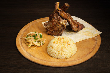 Barbecued ribs with vegetables on cutting board