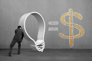 Businessman pushing granite lightbulb shape with dollar sign