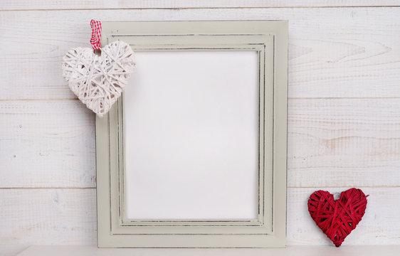 Love concept. Empty picture frame rustic , shabby chic, vintage style and heart shape decoration. Scandinavian style home interior decor. Copy space image