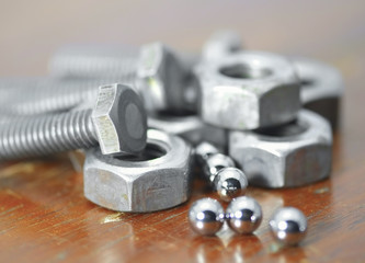 Fototapeta na wymiar Nuts, bolts and bearing balls/Nuts, bolts and bearing balls close up.