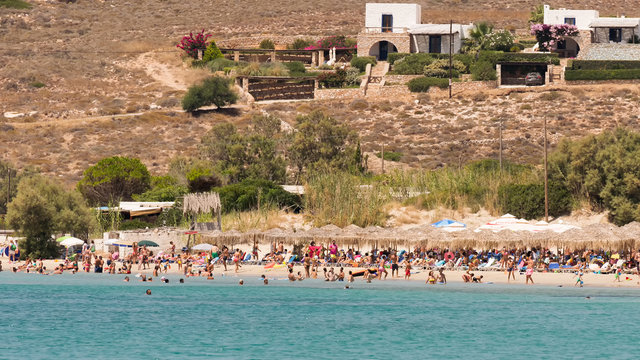  Local people and tourists enjoying their summer vacations at famous Marchello beach in Paros island.