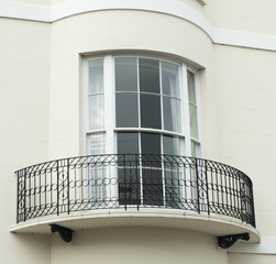 Bow window with narrow balcony set on a white building