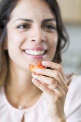 Beautiful Young Woman Eating a Strawberry