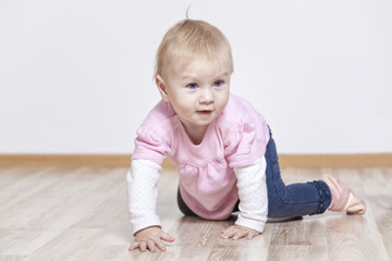 Naklejka premium Baby krabbelt auf dem Holzboden