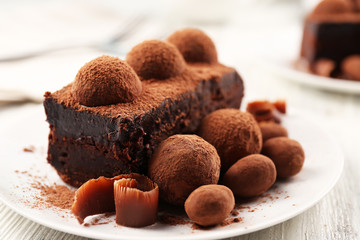 Slices of chocolate cake with a truffle on plate closeup