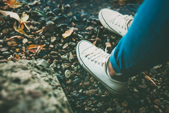 Closeup of white shoes footwear on rocky background. Converse shoes.