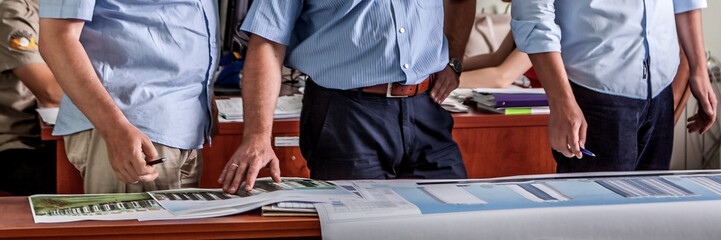 Panoramic view group of business people at work. Close-up employers hands.
