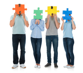 Obraz premium People Covering Face With Puzzle Pieces