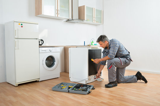 Technician Checking Dishwasher With Digital Multimeter
