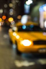 Defocused New York City yellow taxi cab blur at night