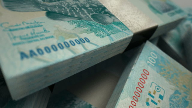 An extreme closeup pan across variously placed bundled wads of brazilian real banknotes