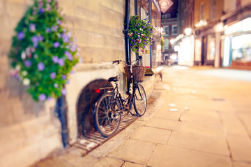 Fototapeta na wymiar Cambridge at Night, Stylish Bike with Basket Left on the Street