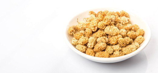 Dried white mulberry in white bowl over white background