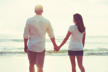 Couple Walking along the Ocean at Sunset