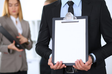 Unknown businessman holds clipboard with copy space area