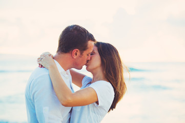Young Couple Kissing on the Beach at Sunset