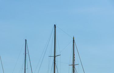 close view of the modern ship masts and ropes in front of a clear blue sky