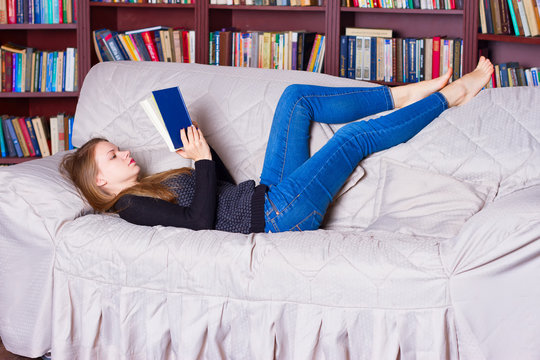 beautiful girl reading book on sofa