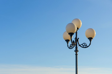 Fototapeta na wymiar vintage lamp post in front of blue sky on a sunny day