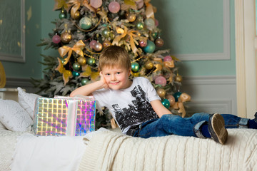 Smiling boy hugging the box close . New year