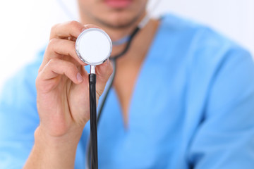 Close-up of male surgeon doctor using stethoscope , focus on stethoscope