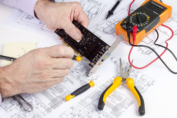 Electronics engineer using a screwdriver to secure a fixing plate to a computer card