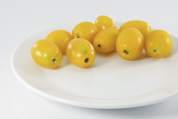 Yellow cherry tomato/Yellow cherry tomato on white plate.