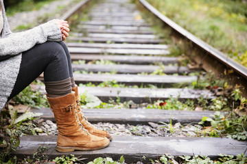 Young woman sitting on rail track