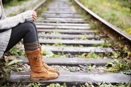 Young woman sitting on rail track