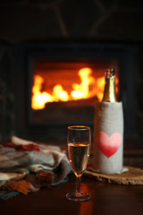 Bottle of wine on table, on fireplace background