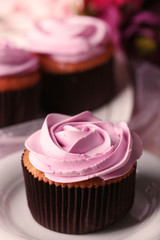 Tasty cupcake on saucer, on light background