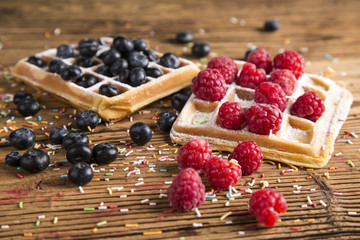 Waffles with whipped cream and raspberries and cranberries
