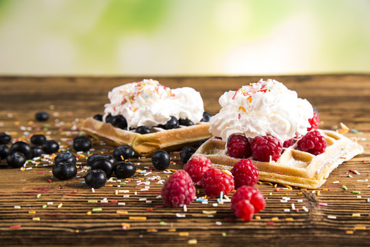 Waffles with whipped cream and raspberries and cranberries
