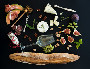 Wine and snack set. Baguette, glass of white, figs, grapes, nuts, cheese variety, meat appetizers,...