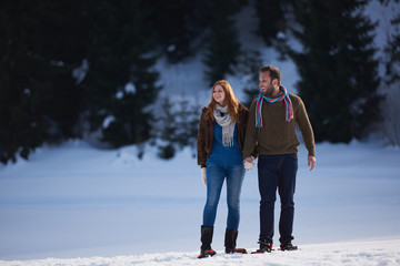 Fototapeta na wymiar couple having fun and walking in snow shoes