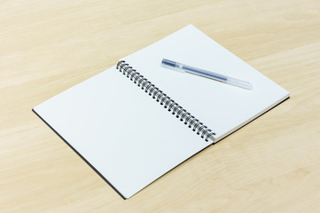 pen and notebook on wooden desk