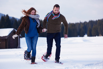 couple having fun and walking in snow shoes