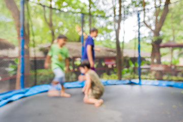Fototapeta na wymiar blur image of kid jumping in trampoline on day time