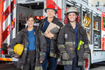 Fototapeta premium Confident Firefighters Standing Against Truck