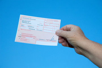 Hand holding german prescription form with fake data