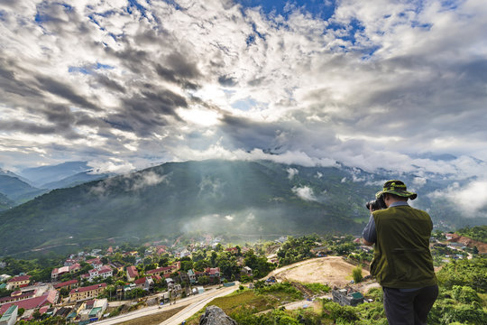 In Ha Giang, Vietnam - September 23rd, 2015: a photographer is dotted landscapes composing sunrise on a hill on an autumn morning in Ha Giang, Vietnam