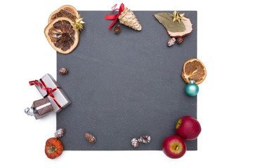 Plate of slate with different christmas decoration around it.