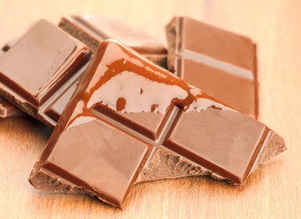 dark chocolate pieces on wood washed down with liquid chocolate
