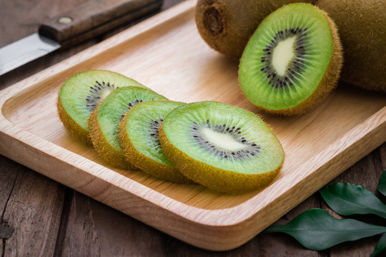 Kiwi fruit slices on wooden plate