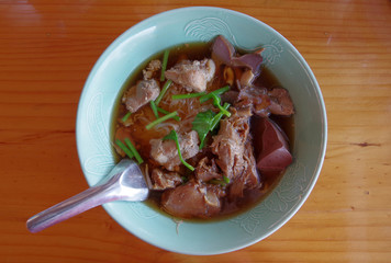 Bowl of noodles with pork on the wooden table