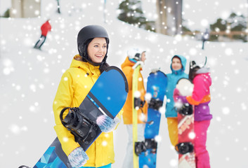 happy friends in helmets with snowboards