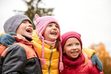 group of happy children hugging in autumn park