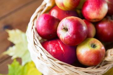 close up of basket with apples on wooden table