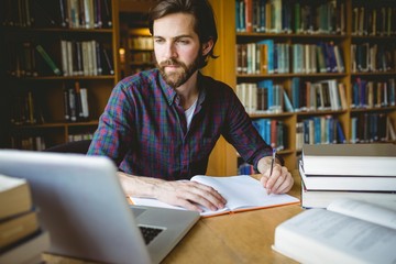 Hipster student studying in library